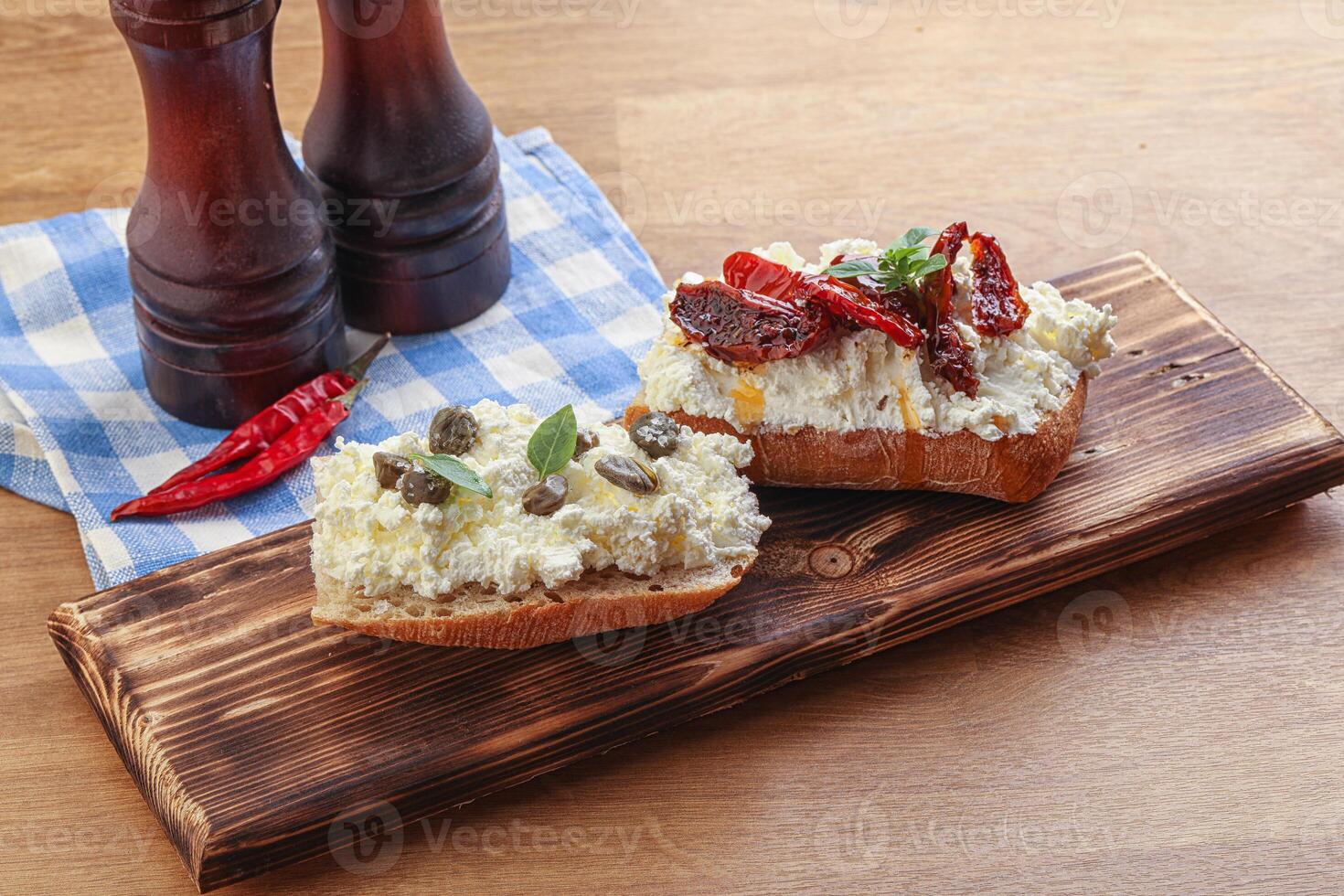 bruschetta with soft cheese capers and tomato photo