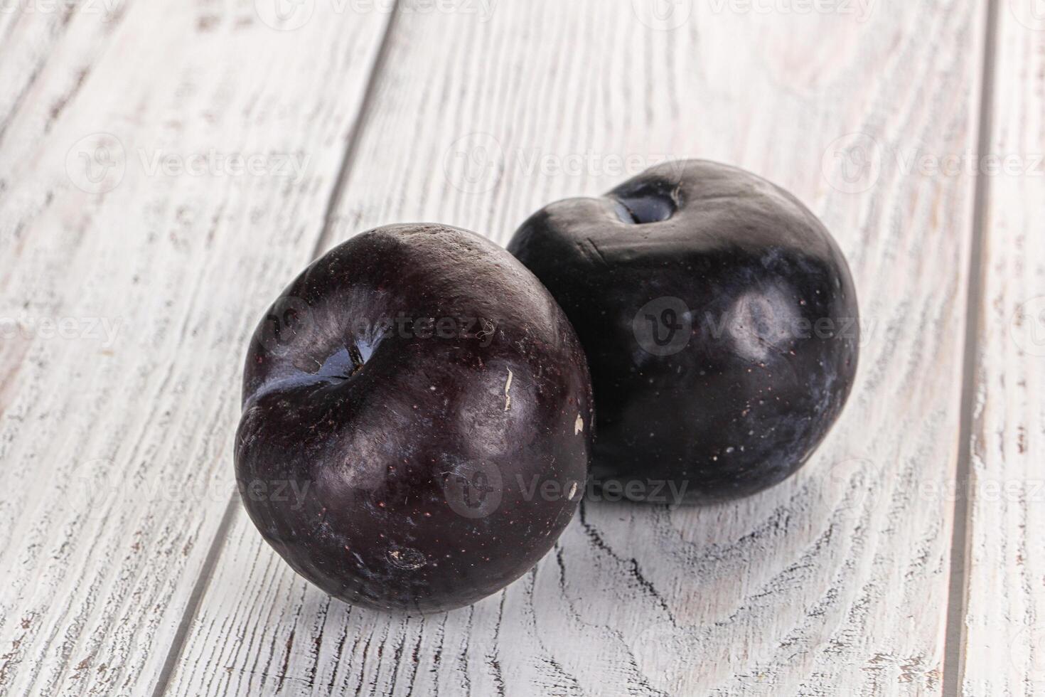 Two ripe sweet black plums photo