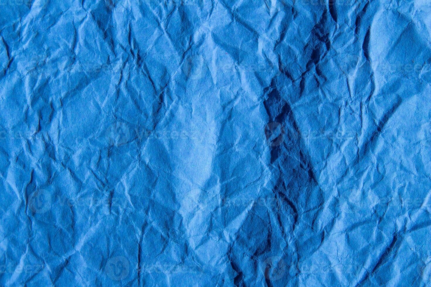 Crumpled blue paper texture background. Wrinkled paper surface for designs. photo