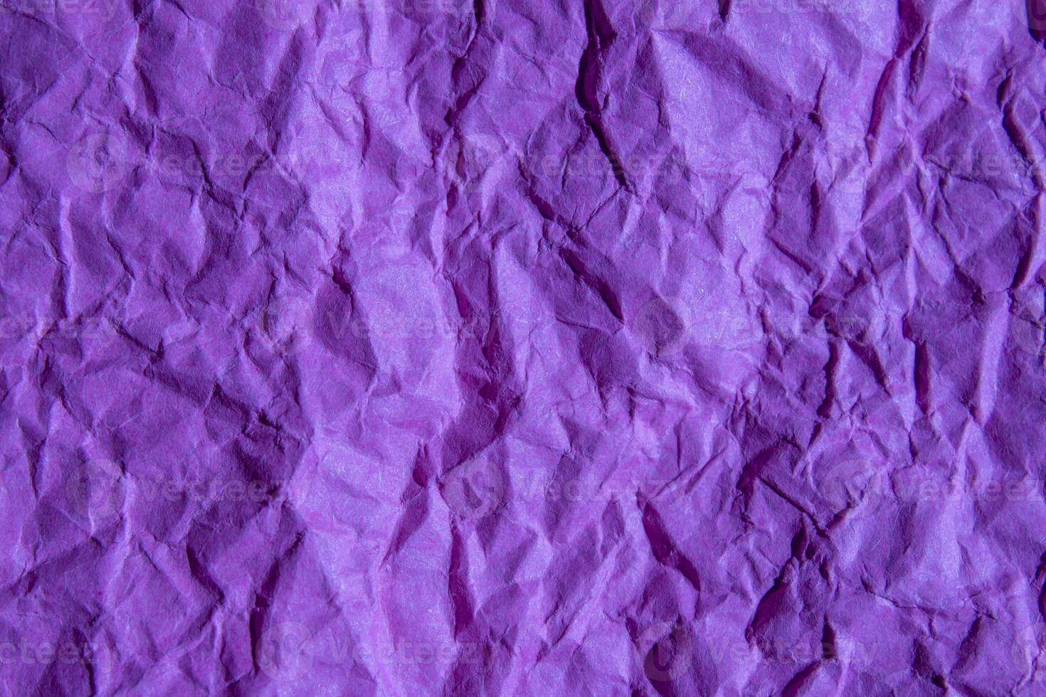 Crumpled purple paper texture background. Wrinkled paper surface for designs. photo