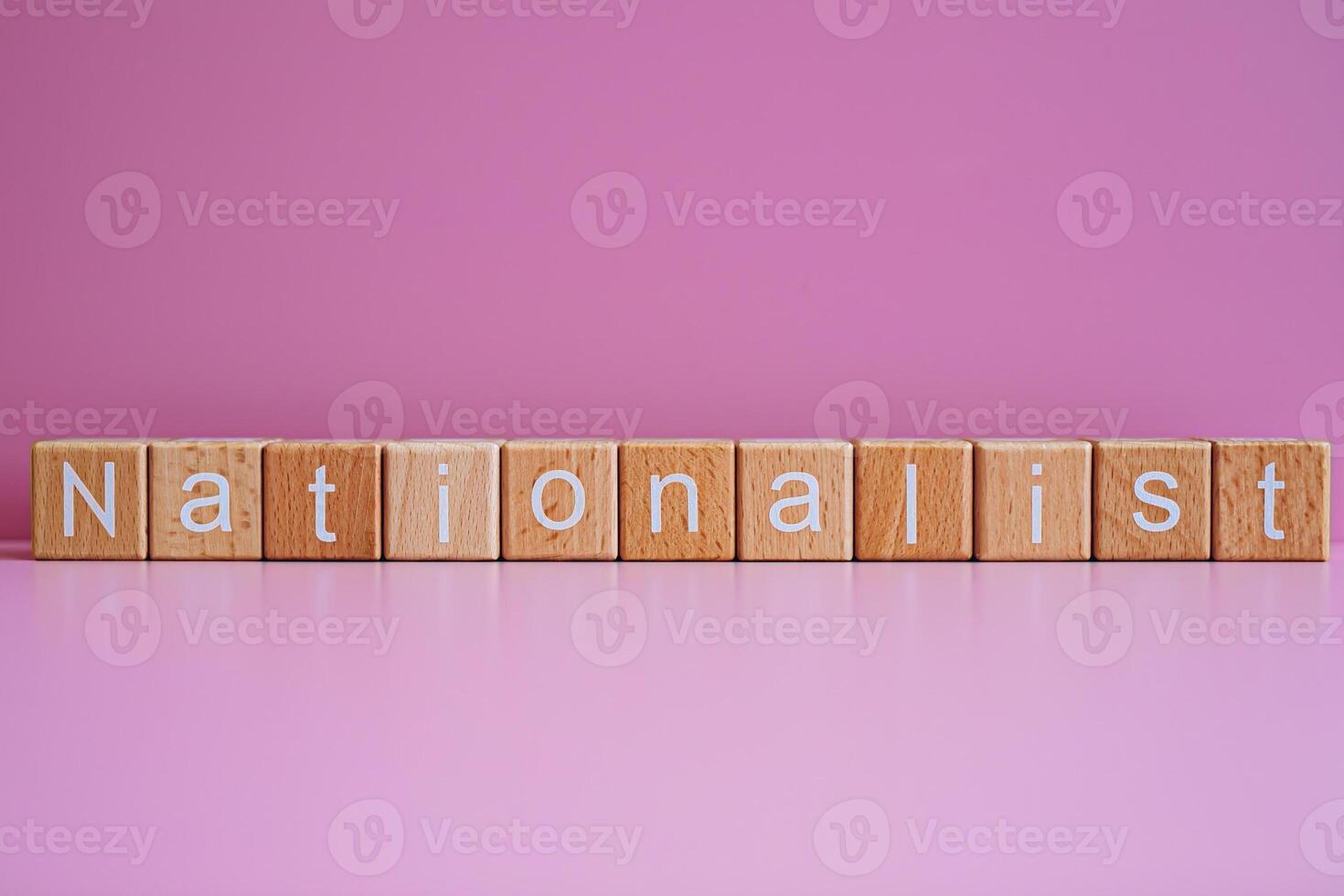 Wooden blocks form the text Nationalist against a pink background. photo