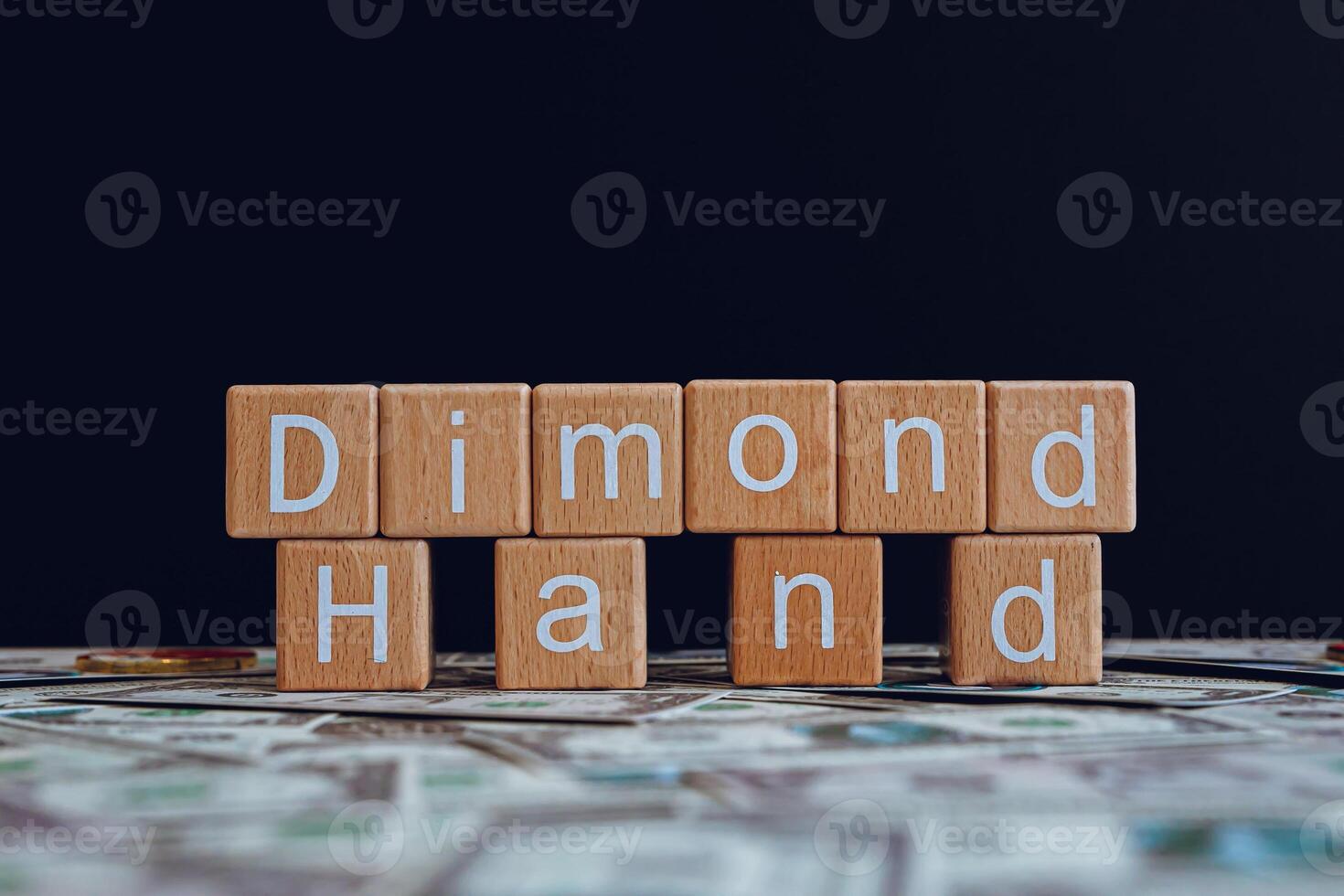 Wooden blocks with the text Dimond Hand on a black background and crypto banknotes scattered on the ground. photo