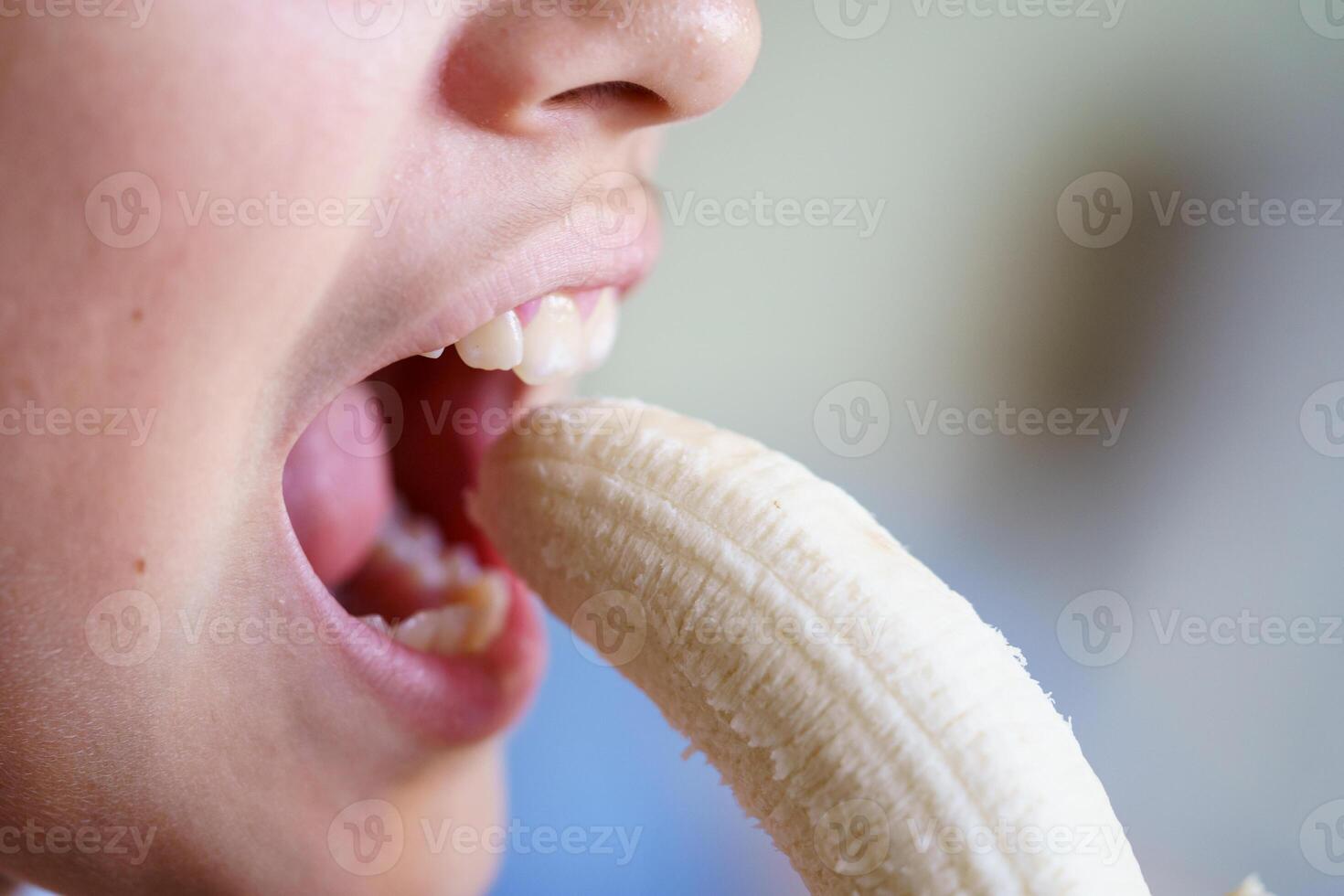 irreconocible niña comiendo delicioso pelado plátano a hogar foto