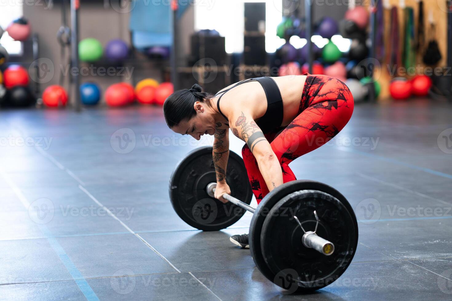 mujer acerca de a levantar peso con bar en un gimnasio foto