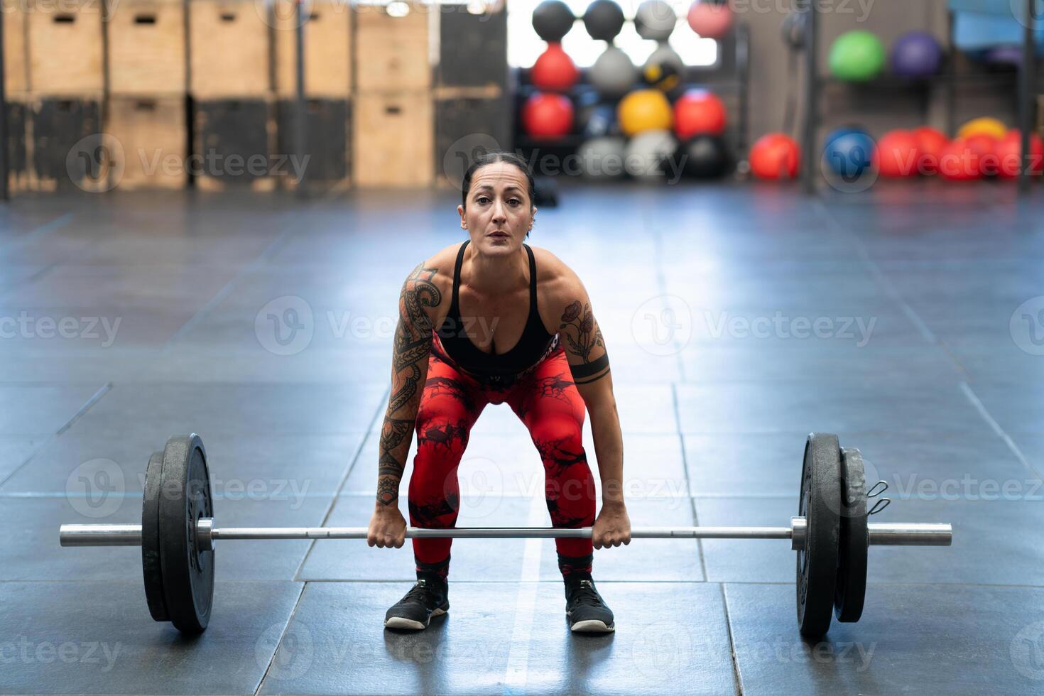 Woman dead-lifting in a cross training gym alone photo