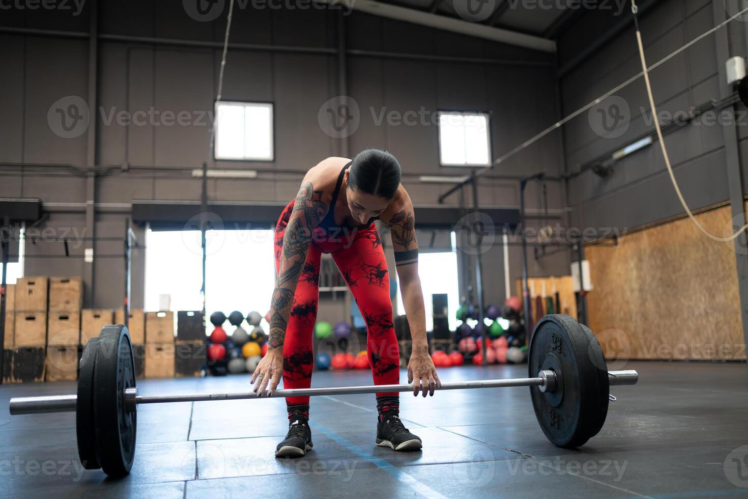 cansado mujer levantamiento de pesas solo en un gimnasio foto