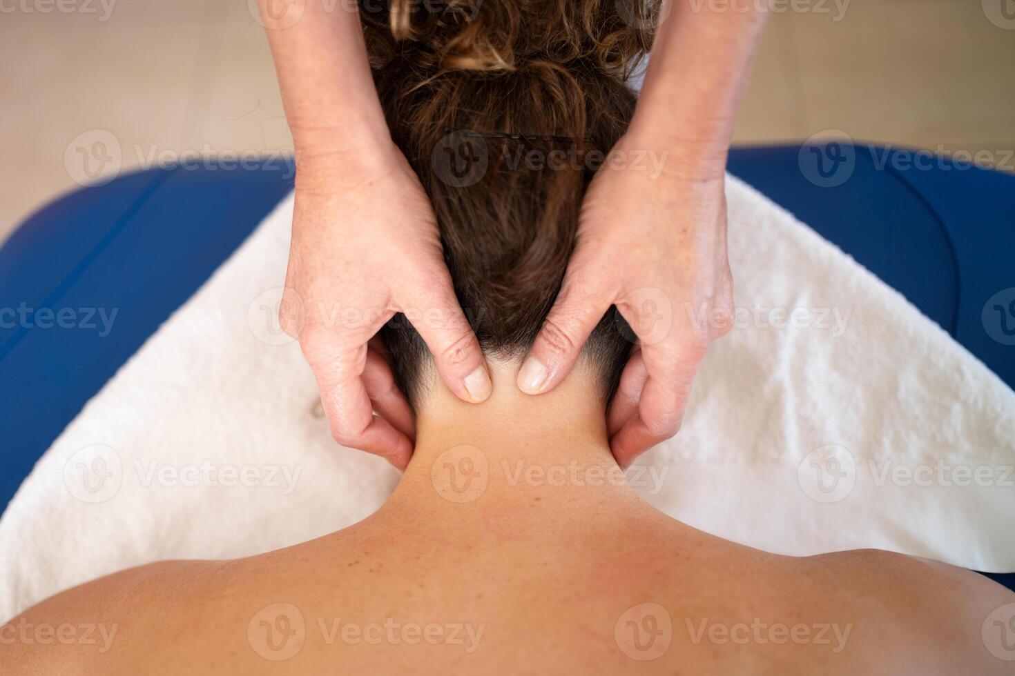 Crop masseuse massaging trigger points on neck of woman photo