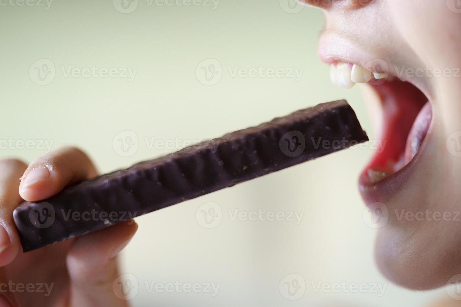Anonymous girl about to eat healthy nutritious protein bar at home photo
