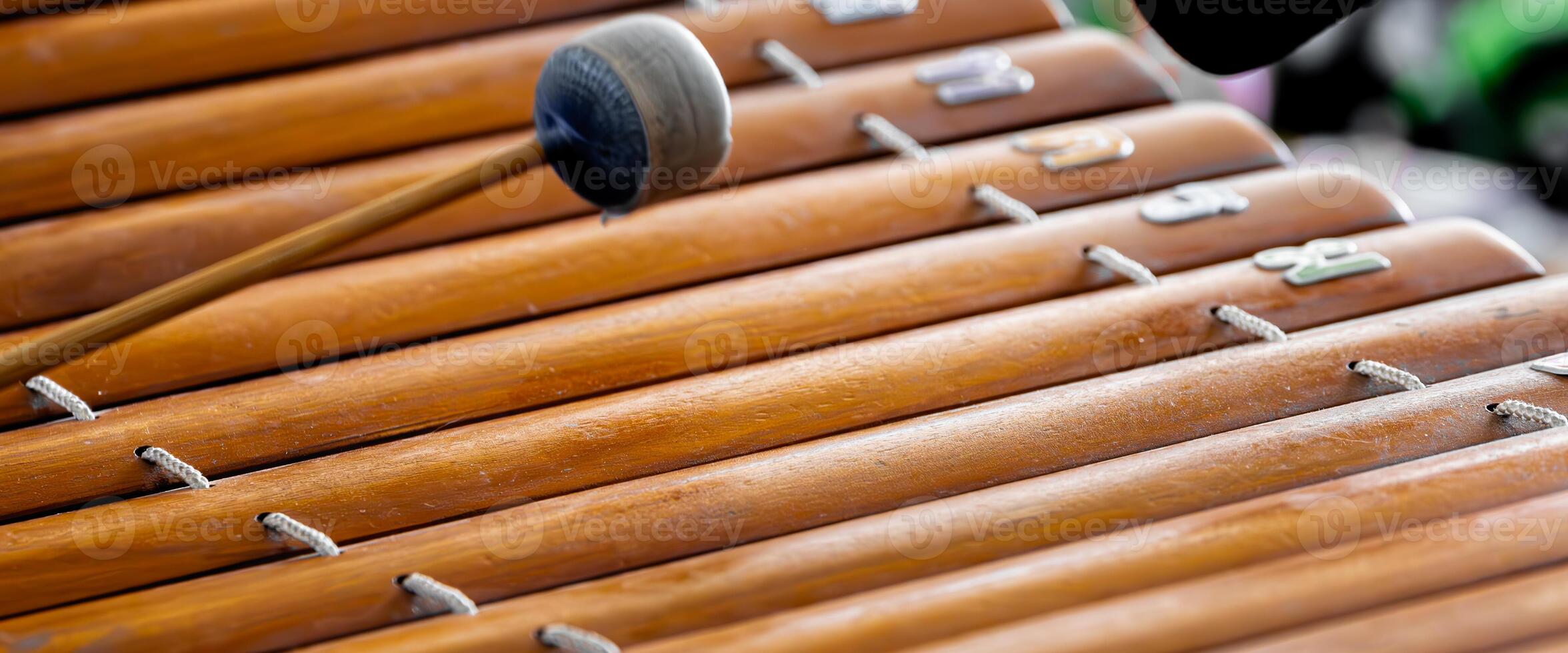 Traditional Thai Wooden Xylophone with Mallet. Close-up of a wooden xylophone, known as 'Ranat' in Thailand, with a focus on the mallet used to play this classic instrument. photo