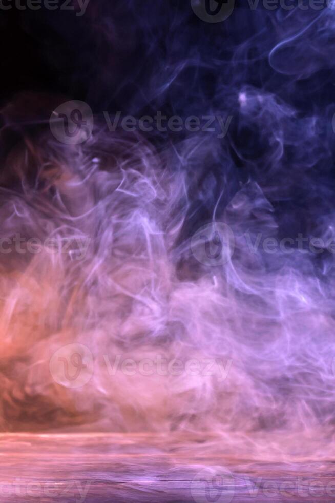 Conceptual image of multi-colored smoke isolated on dark black background and wooden table. photo