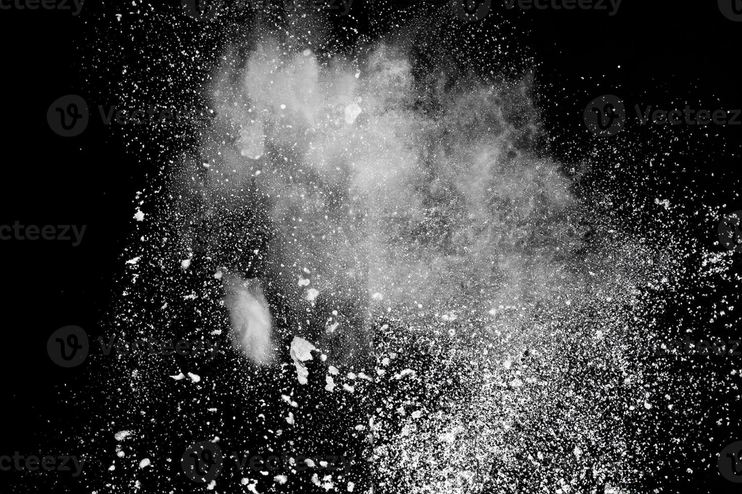 Bizarre forms of white powder explosion cloud against black background.White dust particles splash. photo