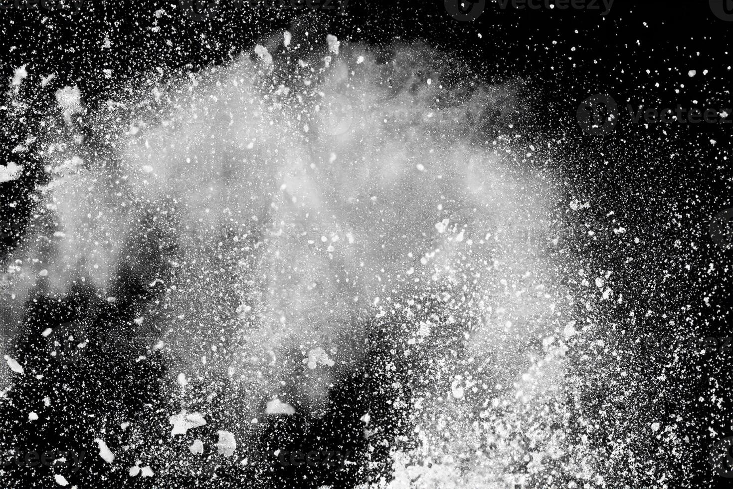 Bizarre forms of white powder explosion cloud against black background.White dust particles splash. photo