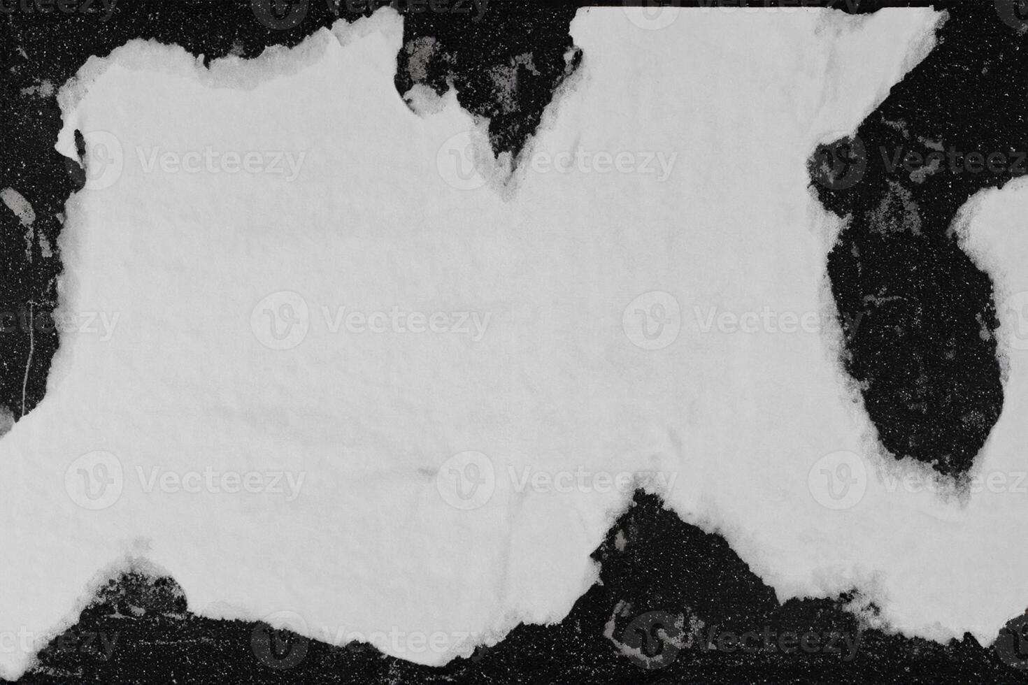 A sheet of white paper pasted on a black wall. photo