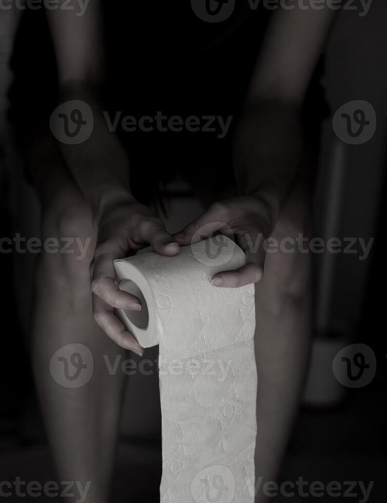 Woman sitting on the toilet. photo