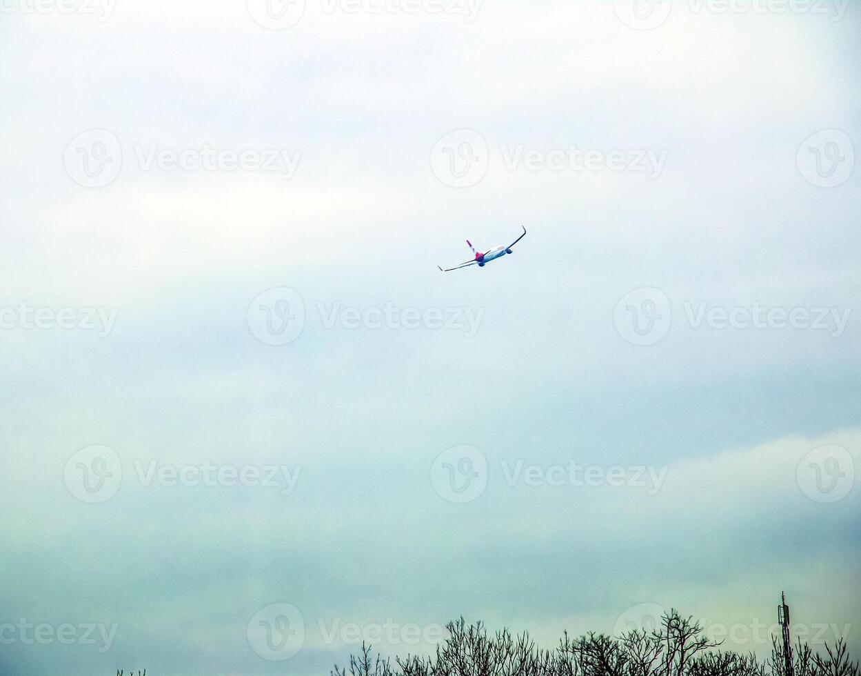 A plane lands at Vienna Airport against a cloudy sky. photo