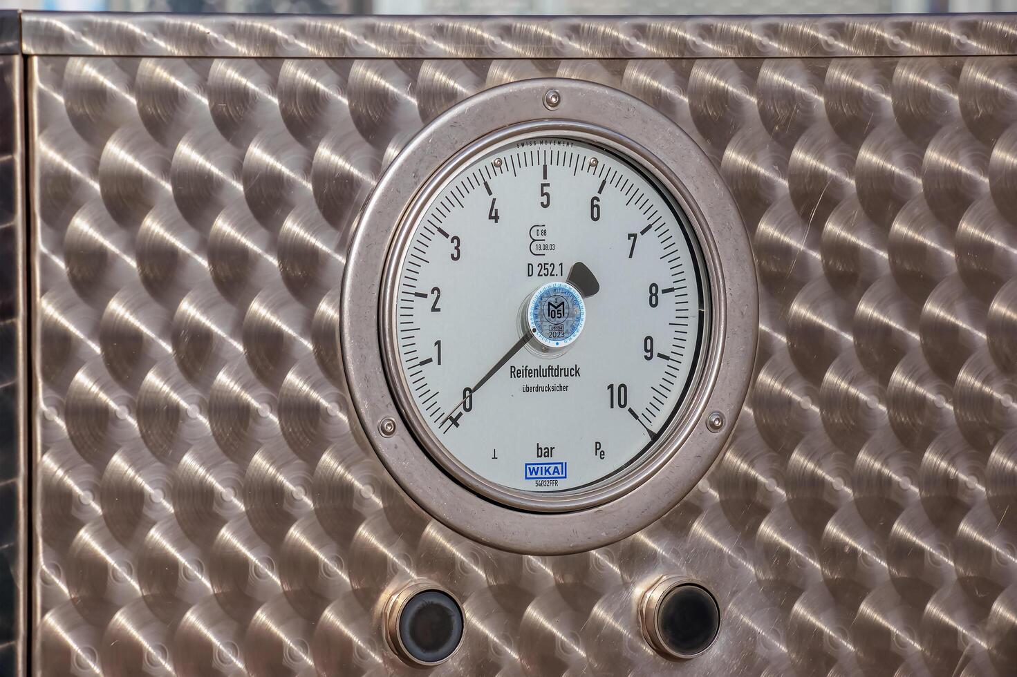 Bratislava, Slovakia - 01.12.2024 A pressure gauge that determines tire pressure. Tire inflation process. photo
