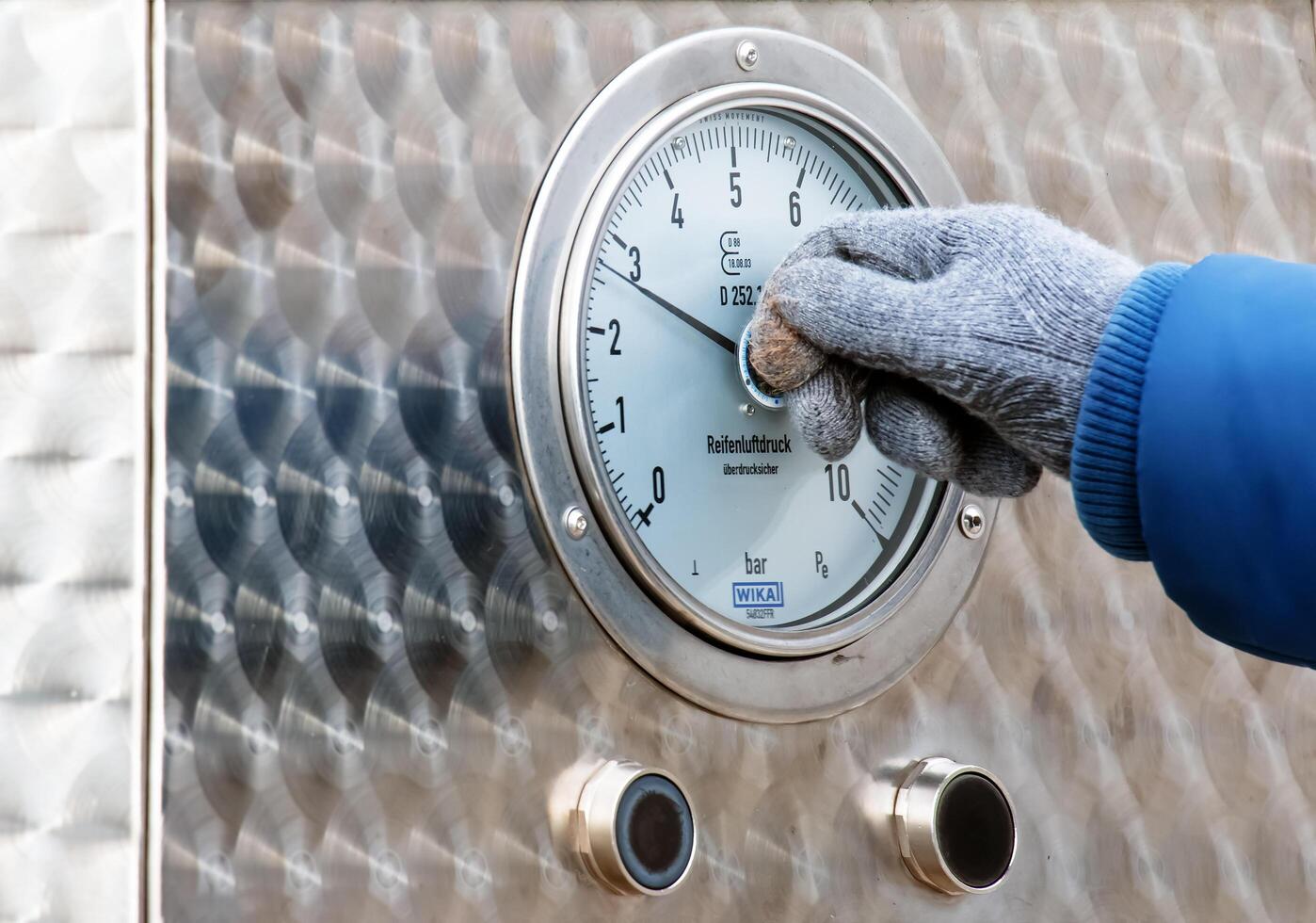 Bratislava, Slovakia - 01.12.2024 A pressure gauge that determines tire pressure. Tire inflation process. photo