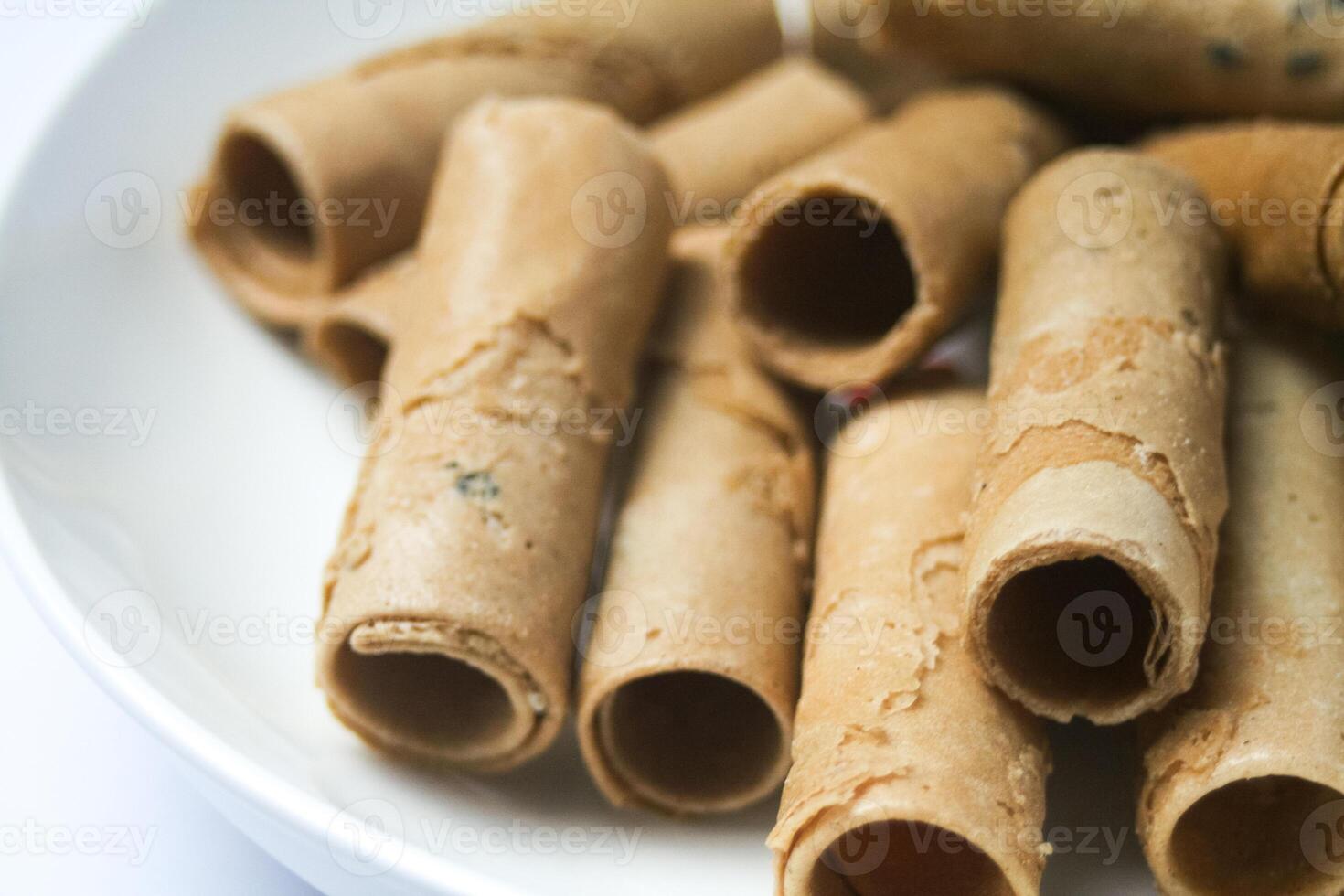 Crispy egg roll or crispy golden curl placed in a white plate, white background. Isolated. photo