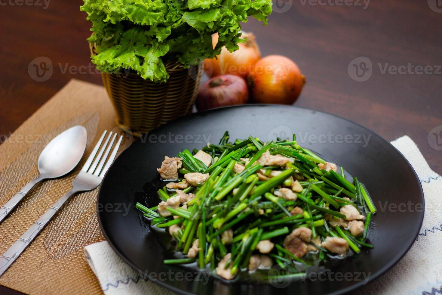 Stir-fried morning glory in a black dish Stir-Fried Morning Glory is also one of the most delicious dishes you can eat in Thailand. photo