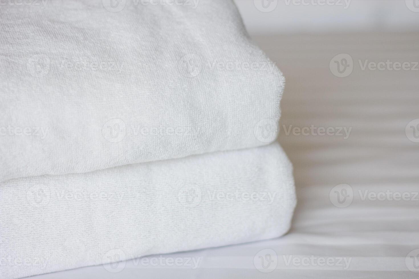 Selective focus on white fresh towels in hotel bed. Room service concept. Closeup white on new bedding and personal hygiene items. photo