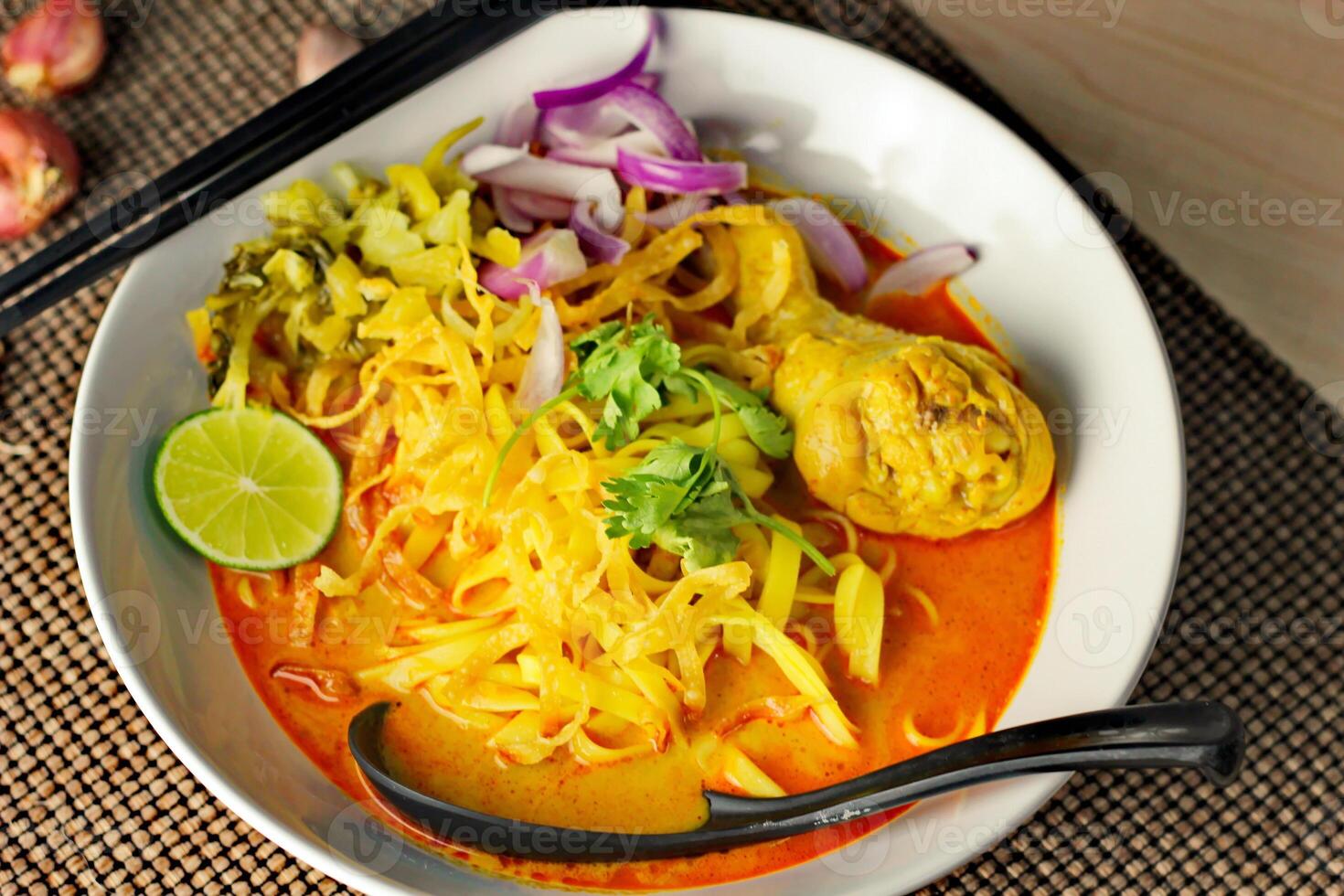 Khao soy Recipe, Curried Noodle Soup with Chicken Served on white Bowl, Thai Food, Curry Noodle, Thai Noodle, Northern Food. photo