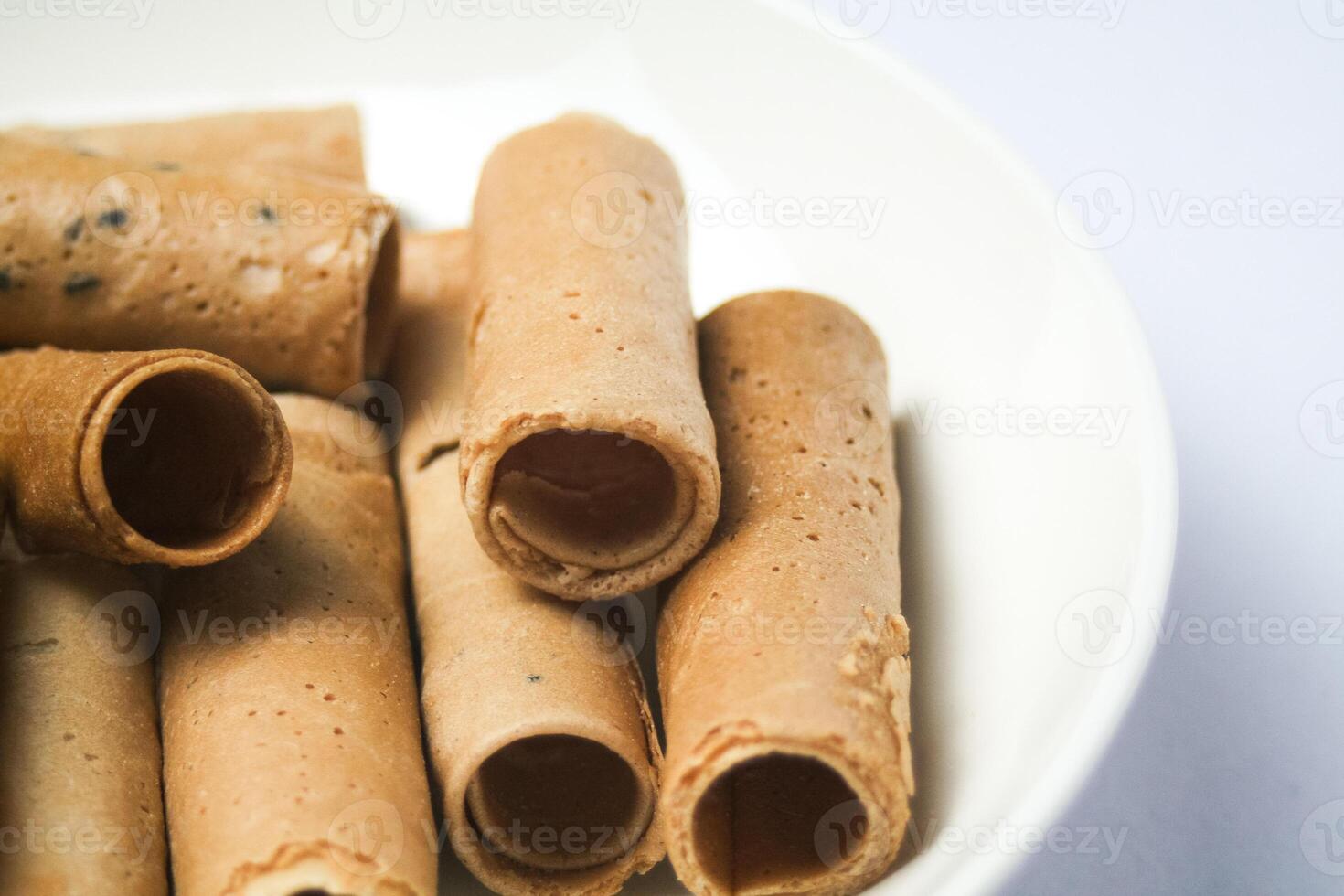 Crispy egg roll or crispy golden curl placed in a white plate, white background. Isolated. photo