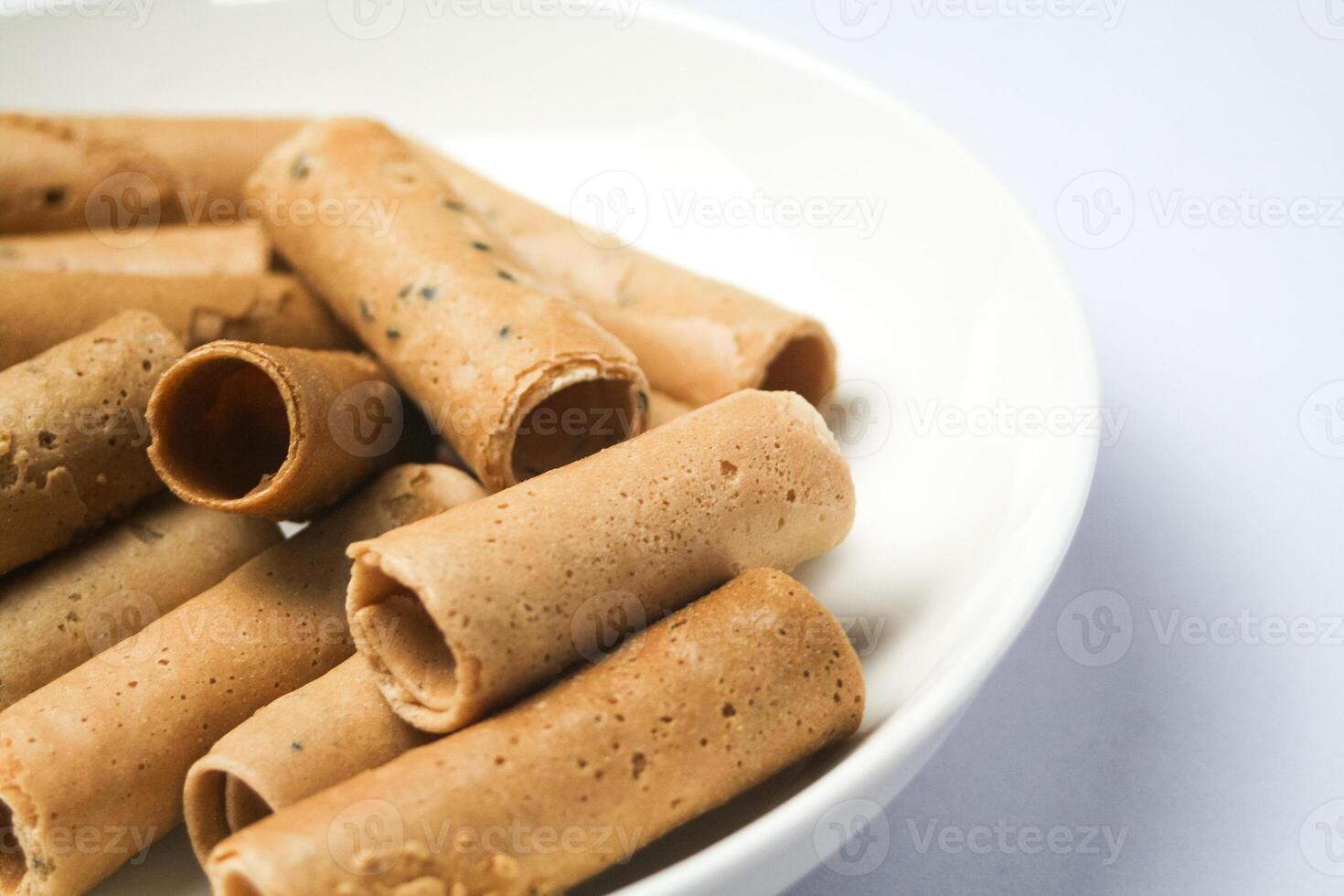 Crispy egg roll or crispy golden curl placed in a white plate, white background. Isolated. photo