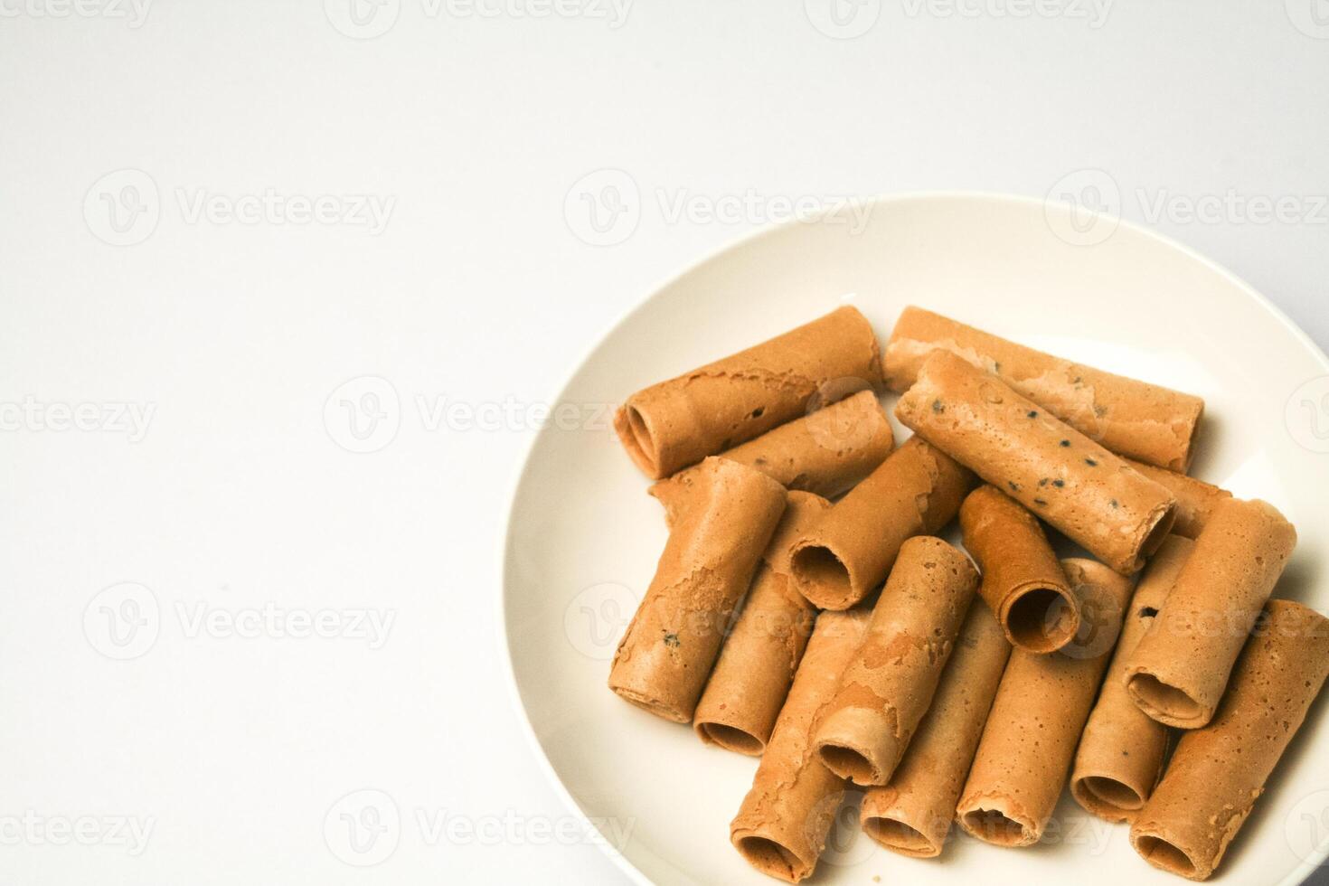 Crispy egg roll or crispy golden curl placed in a white plate, white background. Isolated. photo