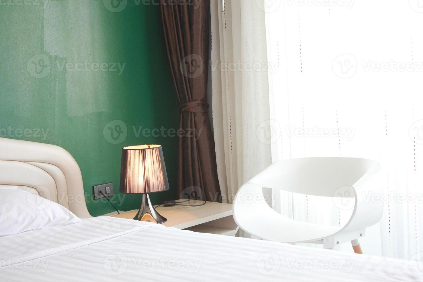 White bed with light lamp and pillow in hotel bedroom, interior design photo