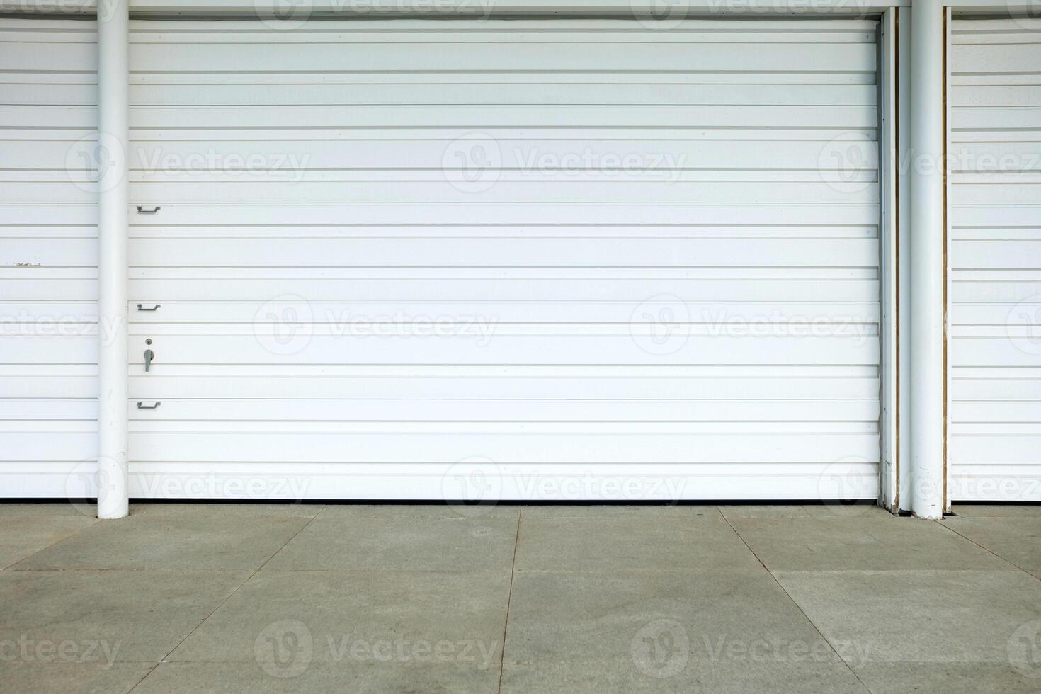 White Folding Metal Door with Concrete Pavement. photo