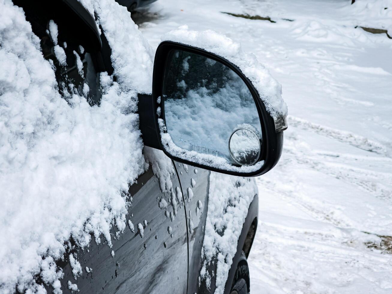 Close-up of a side mirror of a modern car covered in snow photo