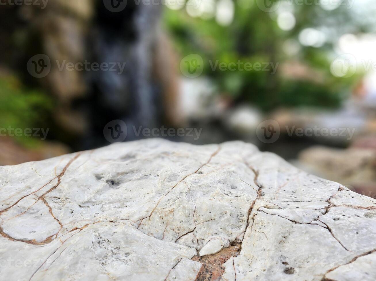 Roca mesa con borroso jardín fondo, adecuado para producto presentación fondo, mostrar, y burlarse de arriba. foto