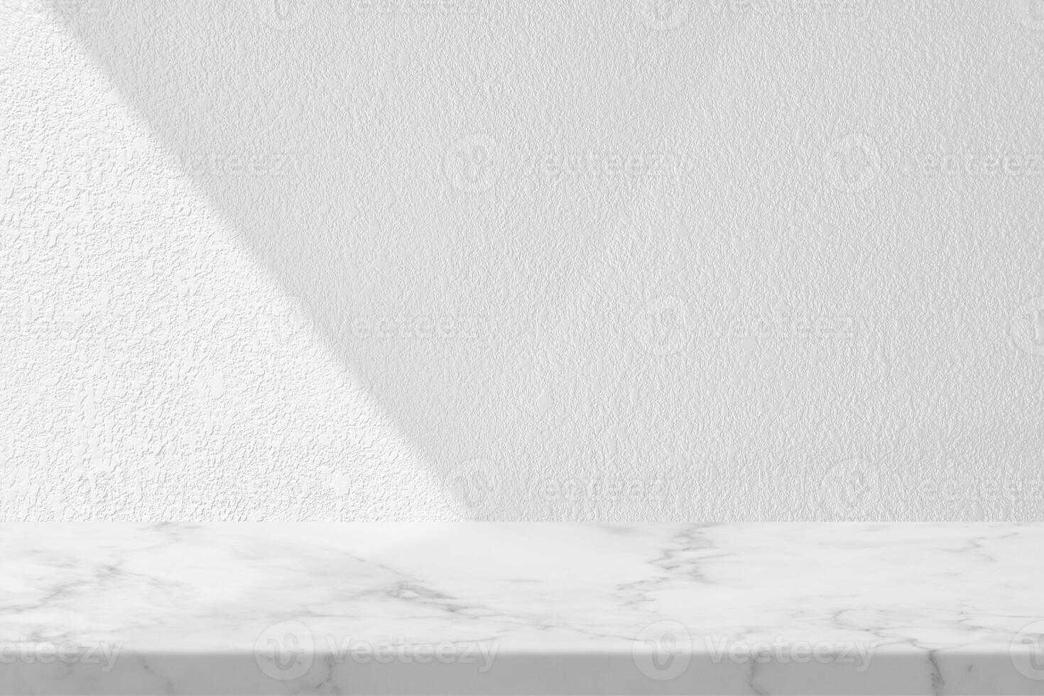 mesa de mármol con fondo de textura de pared de estuco blanco con haz de luz y sombra, adecuada para el telón de fondo de presentación del producto, exhibición y maqueta. foto