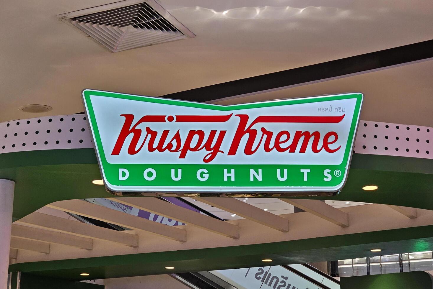 BANGKOK, THAILAND AUGUST 14, 2023 Krispy Kreme Doughnuts Sign. Krispy Kreme is an American multinational doughnut company that was founded July 13, 1937. photo