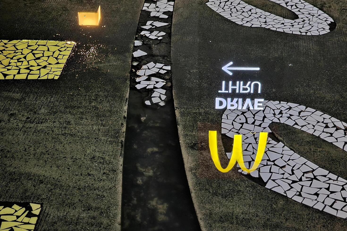 BANGKOK, THAILAND SEPTEMBER 14, 2023 Mcdonald drive thru sign reflection on surface of water on the road. photo