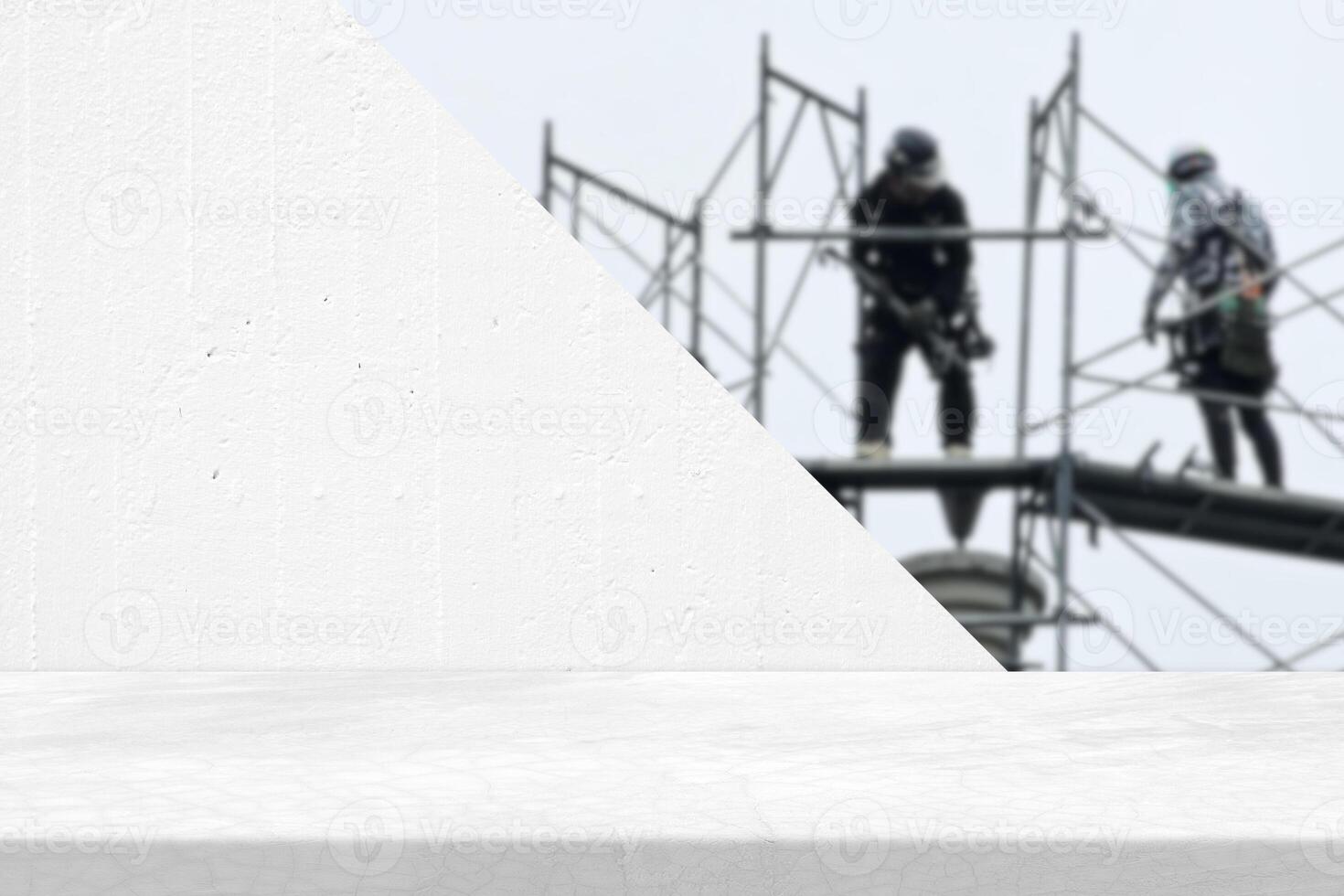 Minimal Loft Table with White Concrete Wall and Blurred Two Workers at the Construction Site Background with Light Leak, Suitable for Product Presentation Backdrop, Display, and Mock up. photo