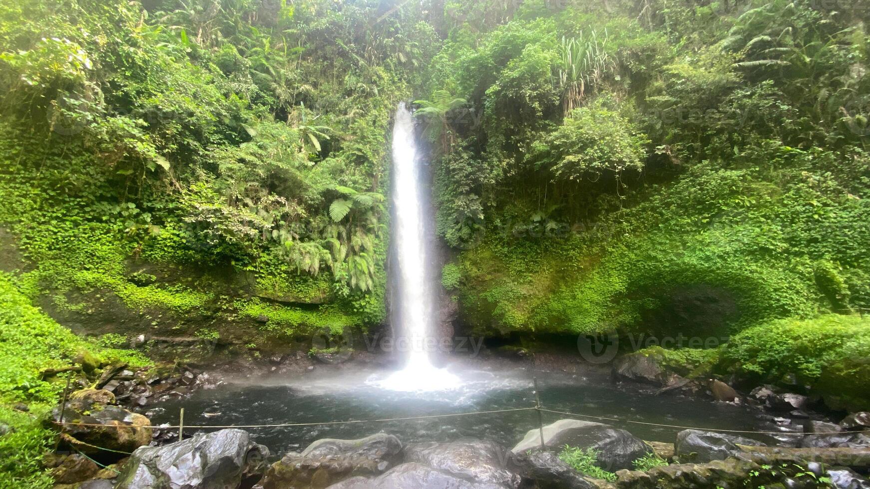 beautiful waterfall, named curug sawer in the middle of indonesia rainforest, asian forest hidden gem photo