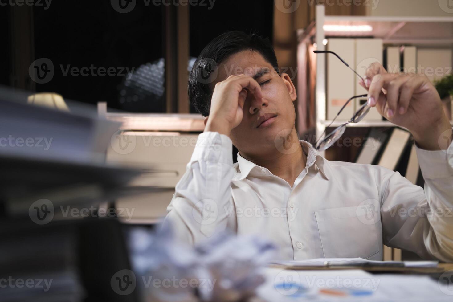 Exhausted young man with laptop in office. photo