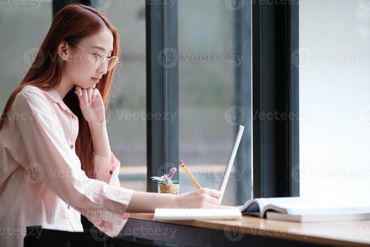 Young collage student using computer and mobile device studying online. photo