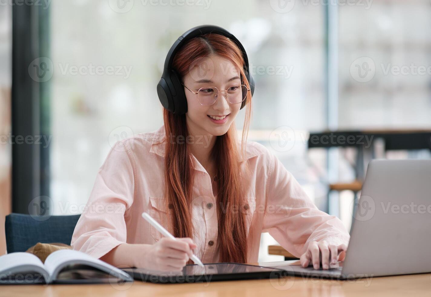 Young collage student using computer and mobile device studying online. photo