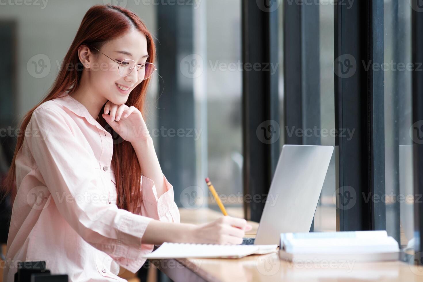 Young collage student using computer and mobile device studying online. photo