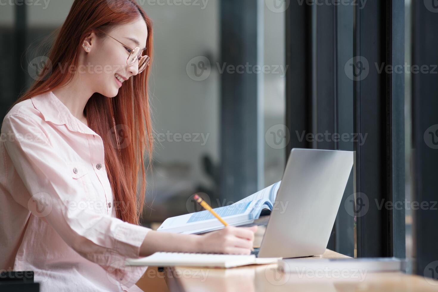 Young collage student using computer and mobile device studying online. photo