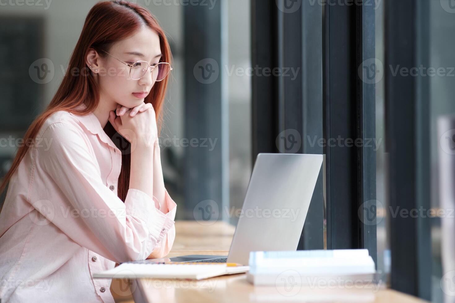 Young collage student using computer and mobile device studying online. photo