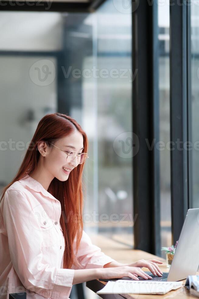 Young collage student using computer and mobile device studying online. photo