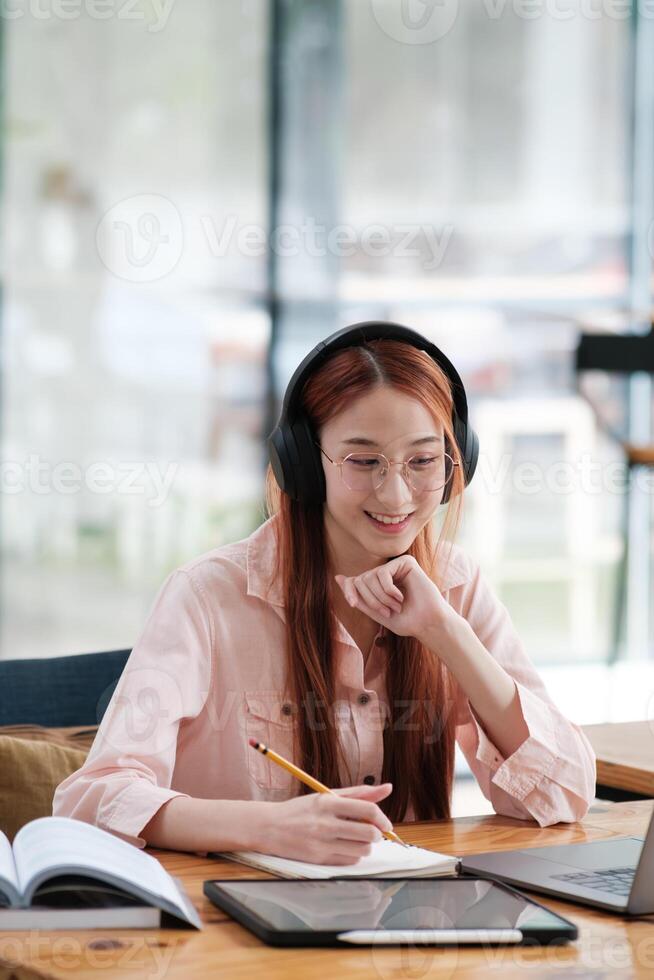 Young collage student using computer and mobile device studying online. photo