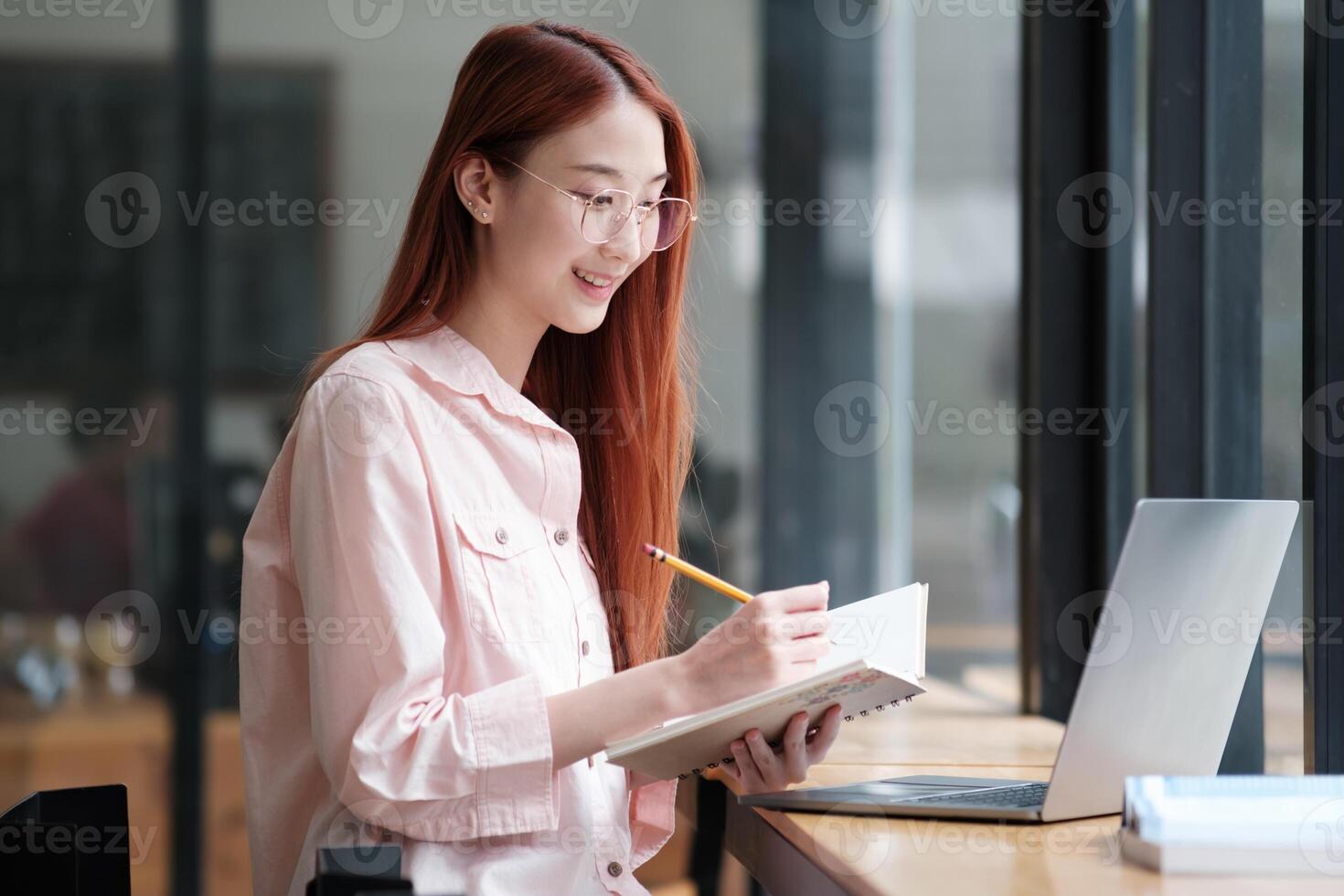 Young collage student using computer and mobile device studying online. photo