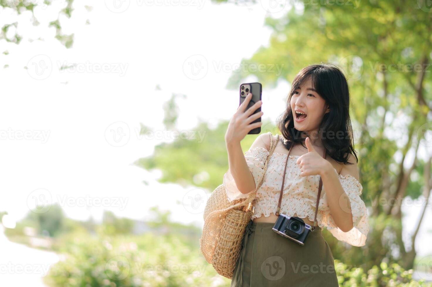 Portrait of asian young woman traveler with weaving hat, basket, mobile phone and camera on green public park background. Journey trip lifestyle, world travel explorer or Asia summer tourism concept. photo