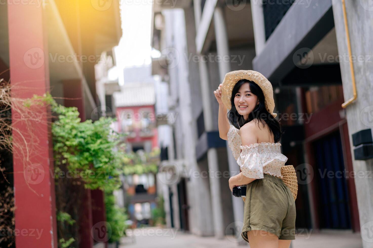Happy youth asian woman with camera travels street city trip on leisure weekend. Young hipster female tourist sightseeing summer urban Bangkok destination. Asia summer tourism concept. photo