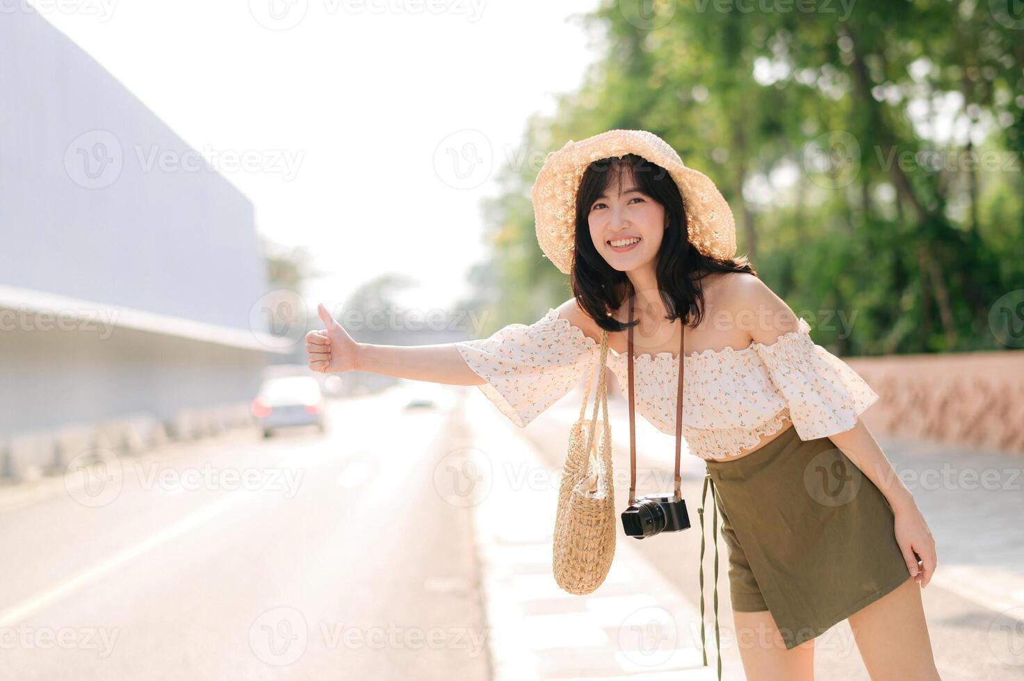 retrato de asiático joven mujer viajero con Costura sombrero y cesta y un cámara ondulación mano a amigo por el calle. viaje viaje estilo de vida, mundo viaje explorador o Asia verano turismo concepto. foto