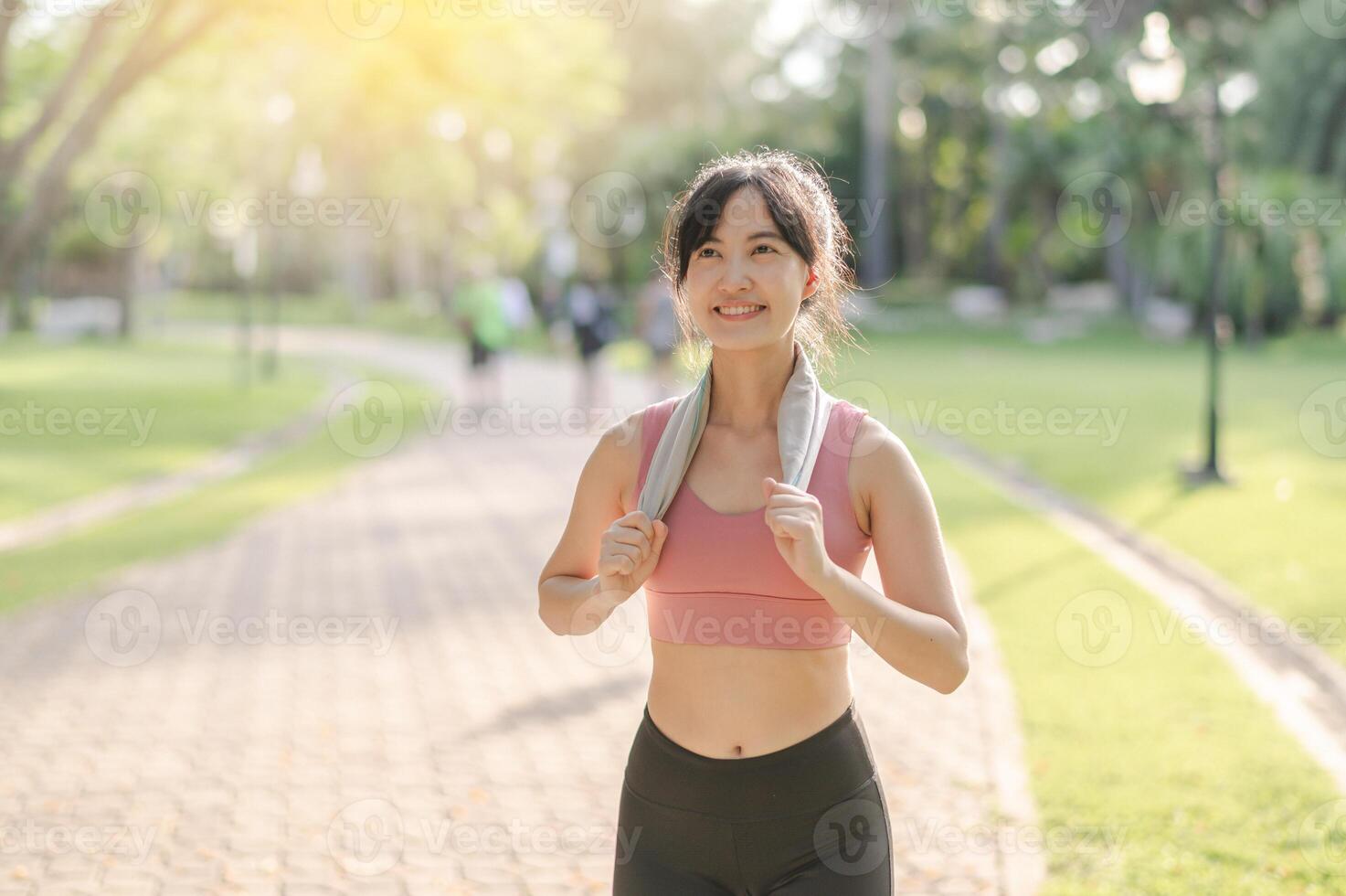 Fit happy smile 30s young Asian woman in sportswear enjoys refreshing sunset run in nature. The silhouette of figure against the setting sun is beautiful sight. Fitness, health, or motivation concept. photo